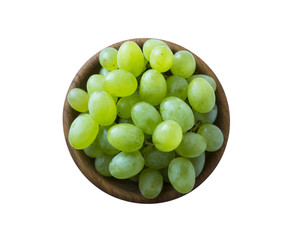 Grapes in a wooden bowl isolated on white background. Green grapes Kish Mish. Vegetarian or healthy eating. Top view.