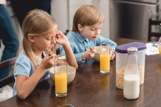 Cute Little Kids Having Cereal For Breakfast Together At Kitchen