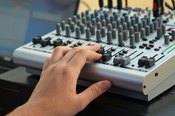 DJ's hand on remote control panel close-up