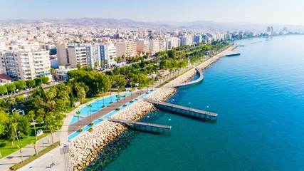 Wall murals Cyprus Aerial view of Molos Promenade park on coast of Limassol city centre,Cyprus. Bird's eye view of the jetty, beachfront walk path, palm trees, Mediterranean sea, piers, urban skyline and port from above