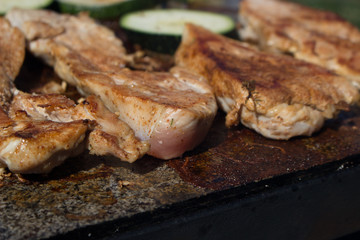 Grilling chicken breast and vegetables on the stone, hot meat dishes