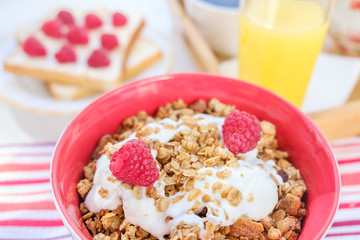 still life: granola with raspberries, toast with curd cheese and raspberries, coffee and orange juice.