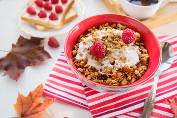 Fototapeta na wymiar still life: granola with raspberries, toast with curd cheese and raspberries, coffee and autumn leaves
