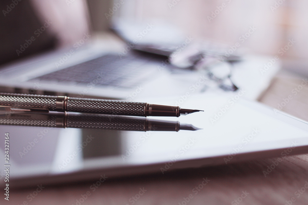 Wall mural close up.stylish fountain pen on blurred workplace background