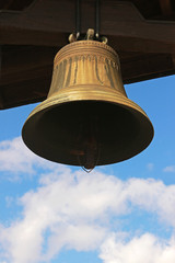 old metal church bell, blue and white sky