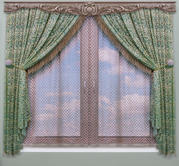 A green curtain with fringe of gold color hangs on a wooden carved cornice above the window overlooking a blue sky with clouds © fotiy