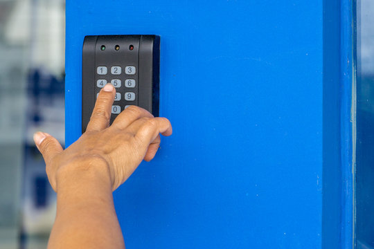Finger is push on the alarm code at home or office., Hand key password on electronic access control door with keypad to unlock the door.