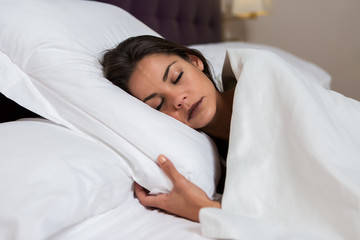 Sleeping charming woman on white bed