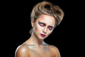 Fototapeta premium Halloween. Portrait of young beautiful girl with make-up. Isolated on black background.