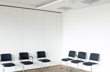 Chairs in waiting room white walls, corner view