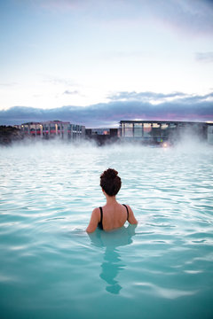 Woman relaxes and enjoys of spa in hot spring Blue Lagoon in Ice