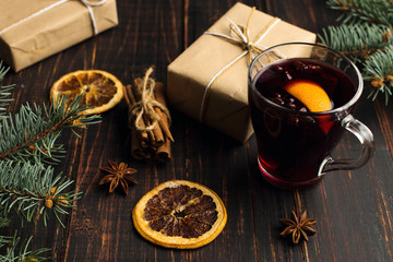 Mulled wine, a gift and spices on the table next to the tree. The concept of Christmas and New...