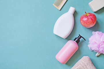 Flat lay organic cosmetics/ Top view shampoo, liquid soap, wooden comb, terry towel, pink sponge and soap. Copy space