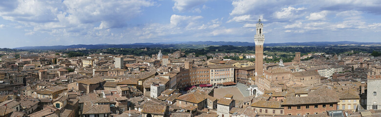 Fototapeta na wymiar Panorama photo of the cityscape of medieval Siena with old town hall (Palazzo Pubblico) in Tuscany, Italy