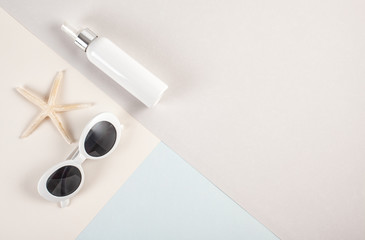 Top view to essential summer accessories sunglasses and sunscreen mockup and  seashells over the pastel background