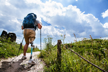 Rear view of a determined disabled man trying Nordic walking