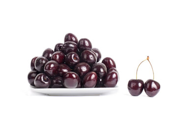 Cherry on a saucer  in water drops  on a table on a white background isolated close up macro