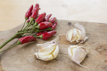 Peperoncini rossi e aglio in camicia sul tagliere