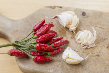 Peperoncini rossi e aglio in camicia sul tagliere