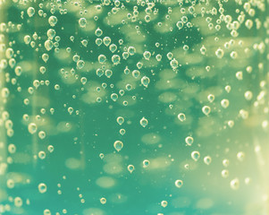 Oxygen bubbles in the bottle with water or drink. Selective focus.