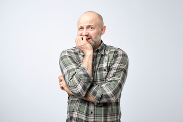 Nervous scared european guy has sorrorful expression, clenches teeth, tries not to cry, finds out about tragic event