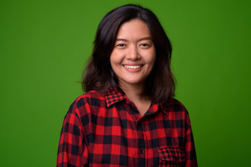 Fototapeta premium Young beautiful Asian hipster woman wearing red checkered shirt