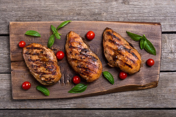 Grilled chicken breast ( fillet ) with basil and tomatoes