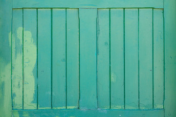 A mint wooden shutter with a stain of lighter paint
