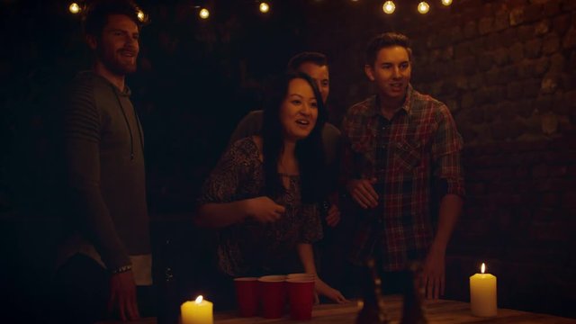Friends playing beer pong 