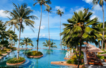 Fototapeta na wymiar Tropical Resort pool with pool bed under umbrellas Samui island sea view