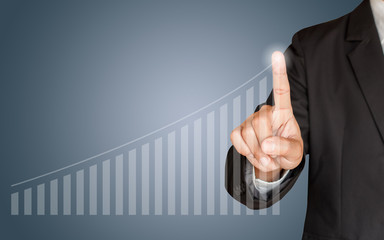 Business man hand touching a graph on blue background, representing business growth
