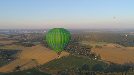 Aerial view Hot air balloon in sky over fields in countryside, beautiful sky and sunset. Aerostat fly over countryside.