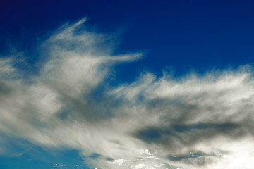 White cirrus clouds on a blue sky as background