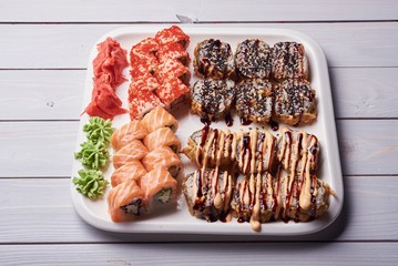 Traditional janese sushi rolls set served on white slate on white background