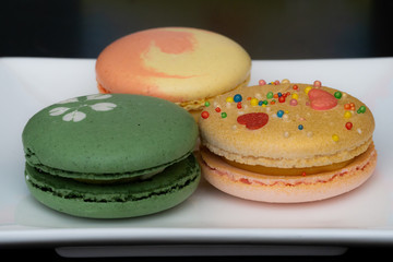 Homemade assorted macarons beautifully decorated with colorful hearts, green tea and yellow and gold color