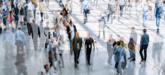 Crowd of anonymous people walking on busy city street