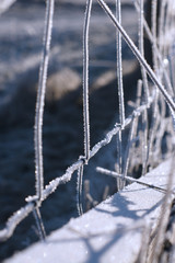 Maschendrahtzaun kompltett mit Raureif bezogen in eine glitzernde Winterlandschaft