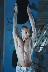 Young and bald sexy guy posing in Moscow city