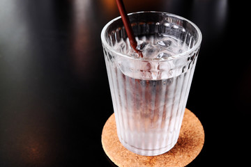 Drinking water in a glass on a black table