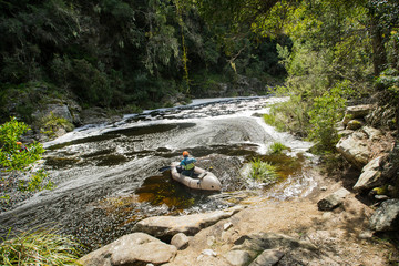 A single pack raft seting off down a wild river through a jungle