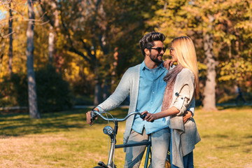 Fototapeta na wymiar Portrait of happy young couple in love with a bicycle on sunny day in the park.