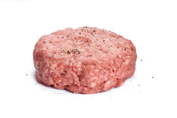 A side view of a raw beef burger isolated on a white background.