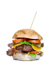 A cheese burger with lettuce, tomatoes and sesame bread bun isolated on a white background.