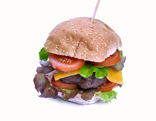 A cheese burger with lettuce, tomatoes and sesame bread bun isolated on a white background.
