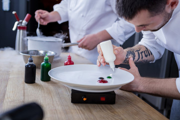 Shared order. Good creative cooks preparing a delicious dish while working together