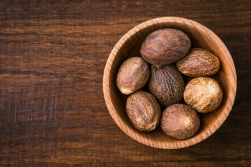Nutmeg, close-up, aromatic spice, wooden background