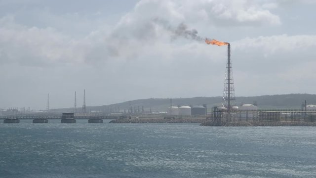 Flare stack of petrochemical refinery on strong wind