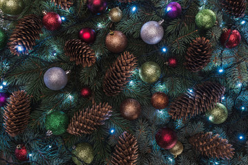 Obraz na płótnie Canvas close-up view of beautiful christmas tree with pine cones, colorful balls and illuminated garland