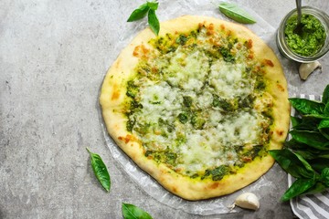 Homemade Pesto Pizza with white sauce overhead view