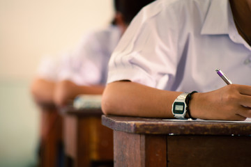 Fototapeta premium School students taking exam writing answer in classroom with stress